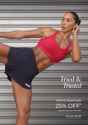 Woman in black shorts, red sports bra striking active pose. Text: Tried and trusted, Active Essentials, 25% off. Selected Styles only. T&Cs apply. Shop Now