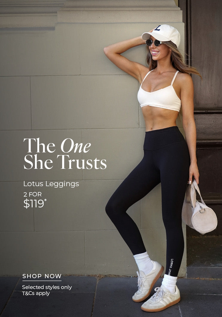 Woman leaning against a sage-green wall in black Lotus Leggings, a white sports bra, white cap, sunglasses, white crew socks and sneakers, holding a small cream duffle bag. Text: The One She Trust. Lotus Leggings 2 for $119* Selected styles only. T&Cs apply - Shop Now