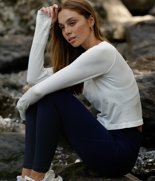 woman wearing navy thermal leggings and a white long sleeve top