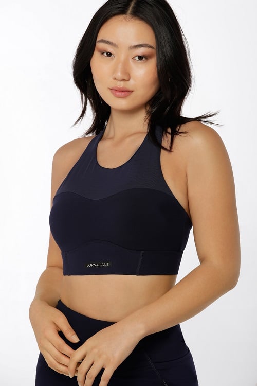 brunette woman wearing navy sports bra with mesh fabric