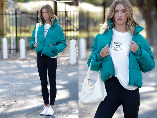 woman wearing teal puffer jacket, a white tee and black full length leggings