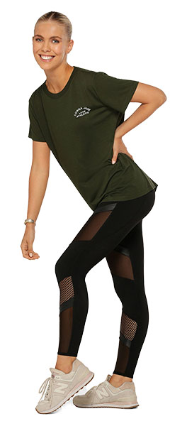 a woman wearing black mesh leggings and a khaki green tee