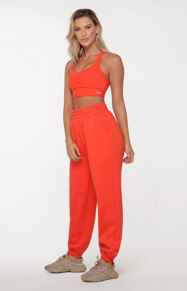 woman wearing sweatpants joggers in bright orange with matching orange sports bra