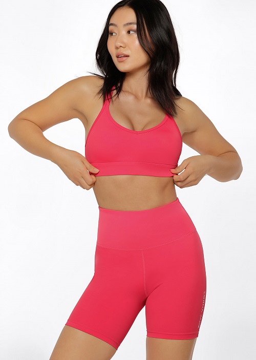 woman wearing all day support hot pink sports bra and matching bike shorts
