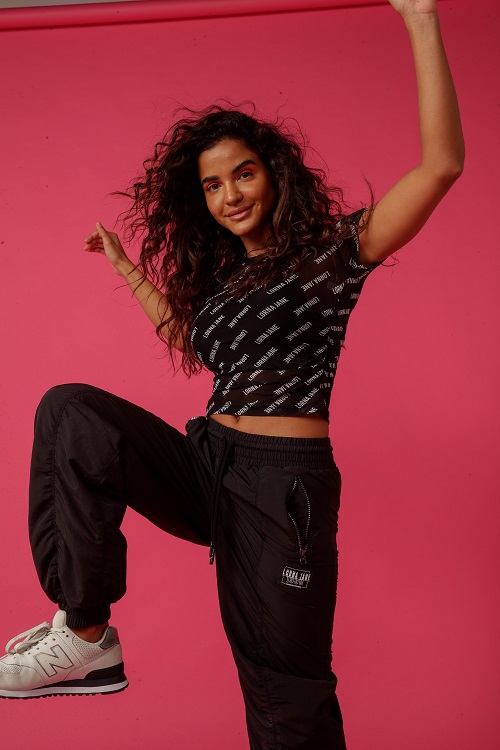 woman wearing black cargo pants with zipper pocket and a tight black crop top